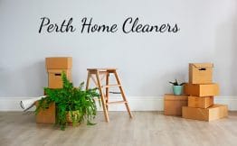 A spotless room with two piles of brown boxes against the wall, a step ladder and a potted plant. The words Perth Home Cleaners on the wall