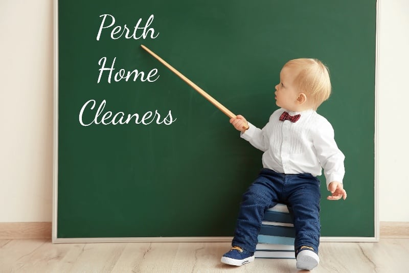 a smartly dressed toddler in front of a blackboard holding a pointer that points to Perth Home Cleaners written on the blackboard